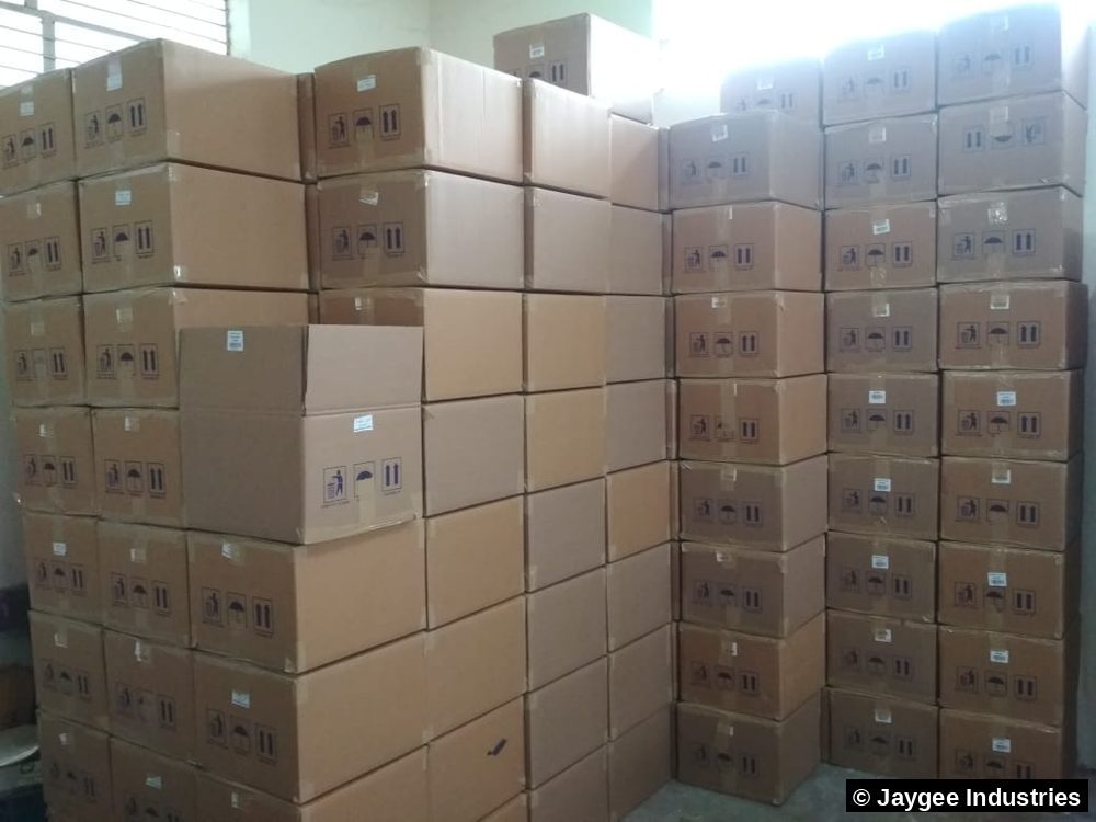 A large wall of stacked export cartons filling the Jaygee Industries warehouse floor